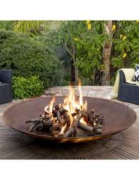 Une image de notre brasero bol avec des flammes dans un jardin