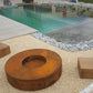 Une image présentant le brasero rond en acier corten positionné près d'une piscine, offrant une ambiance relaxante et élégante.